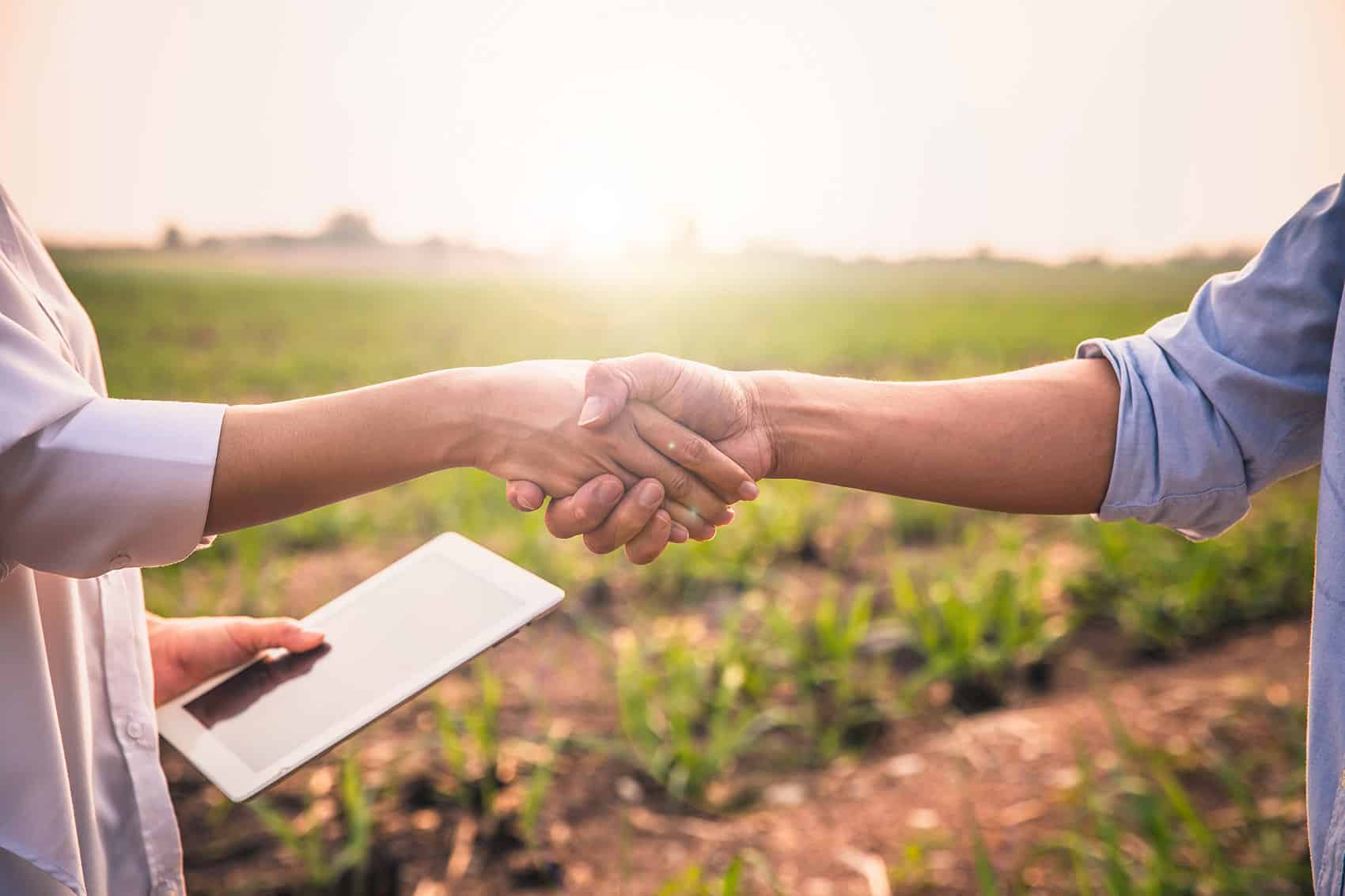 Shaking hands after propane delivery with ag field background